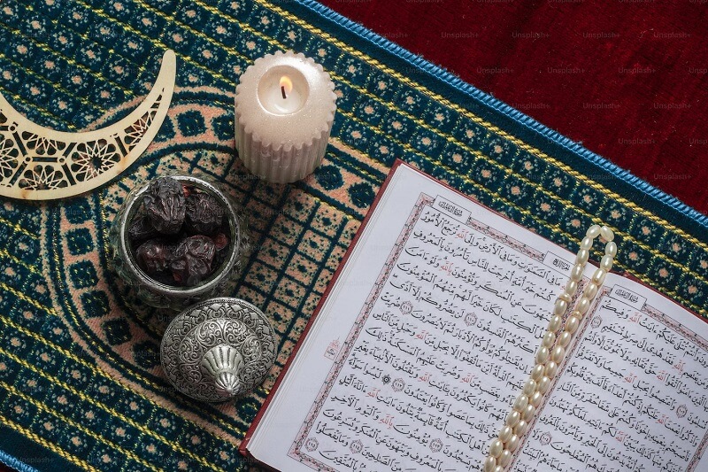 an open book and a candle on a rug