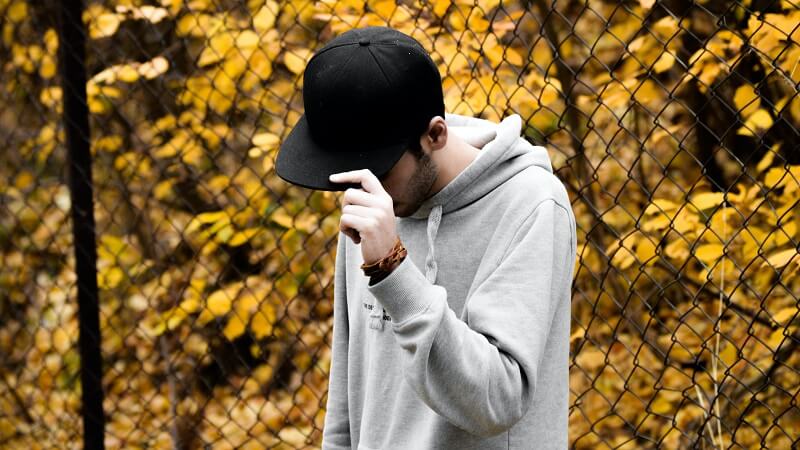 man in black hat and gray hoodie