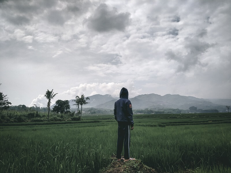 man in black jacket standing on green grass