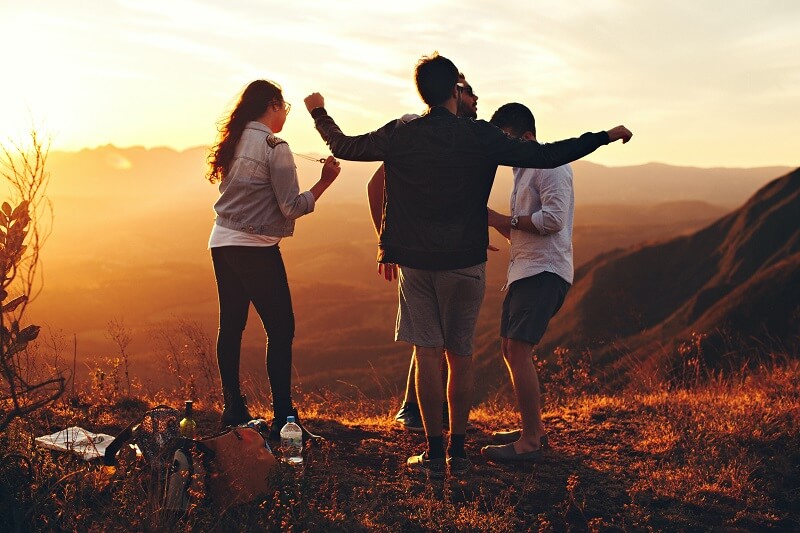 Four people standing on edge of mountain