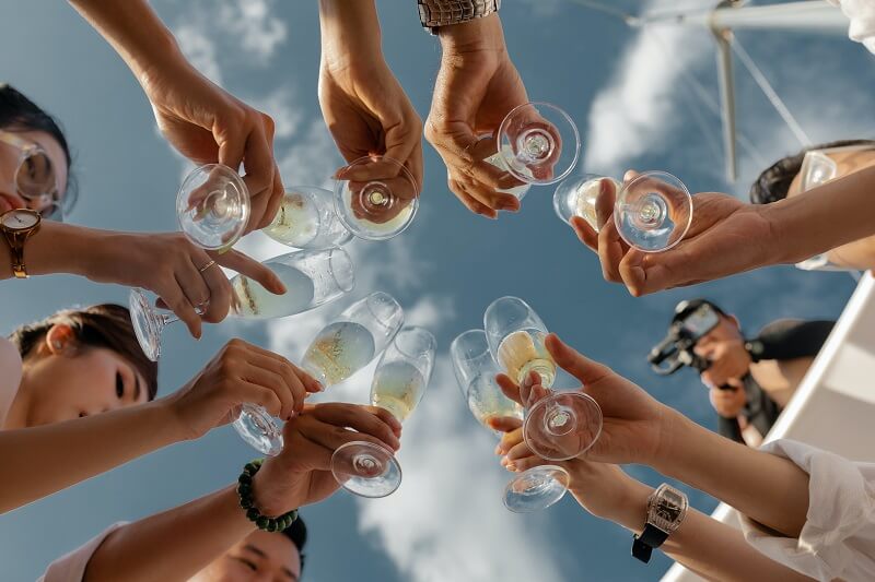 People holding clear glass bottles during daytime