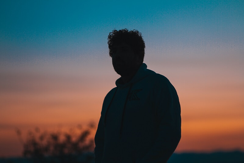 Silhouette of man in black jacket during sunset
